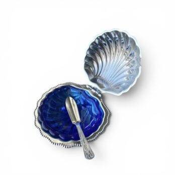 Shell-shaped butter dish with blue glass spoon and saucer