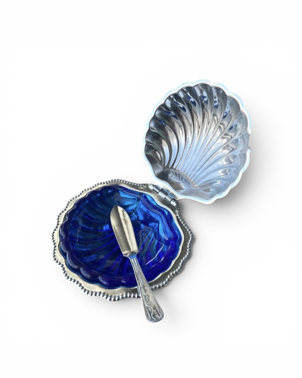 Shell-shaped butter dish with blue glass spoon and saucer